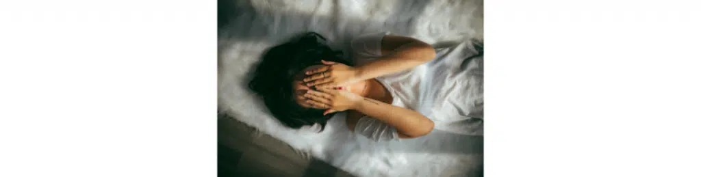 A woman covers her face with her hands
