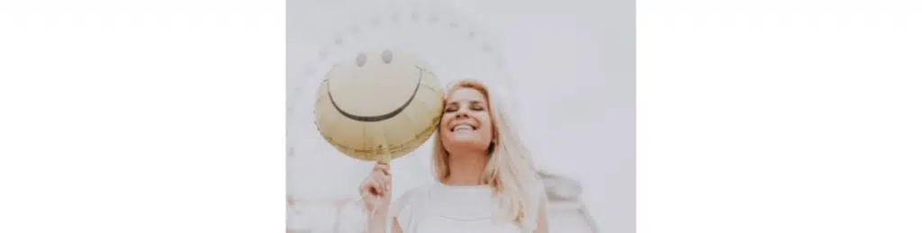 A women with a smiley face balloon